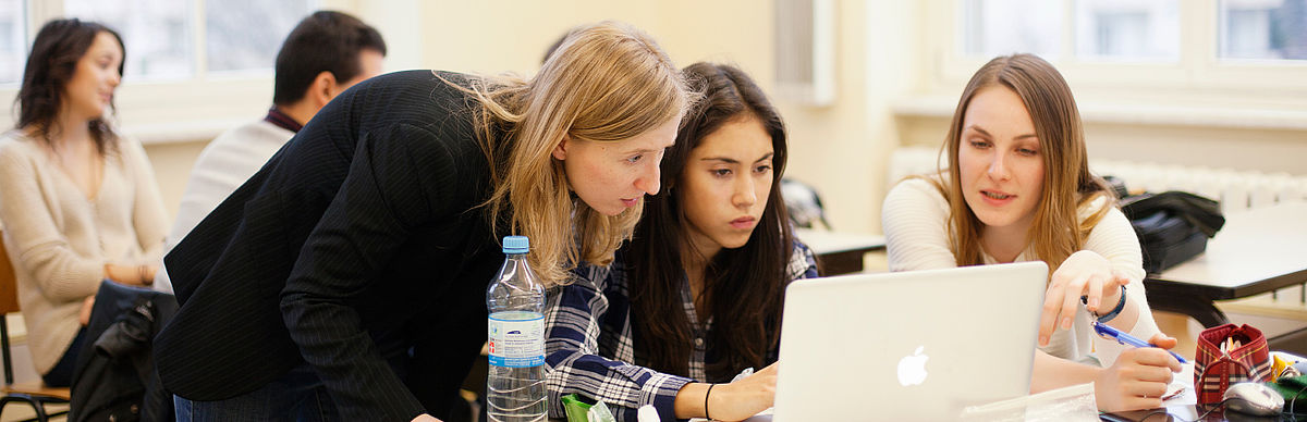 Drei Studentinnen arbeiten an einem Laptop